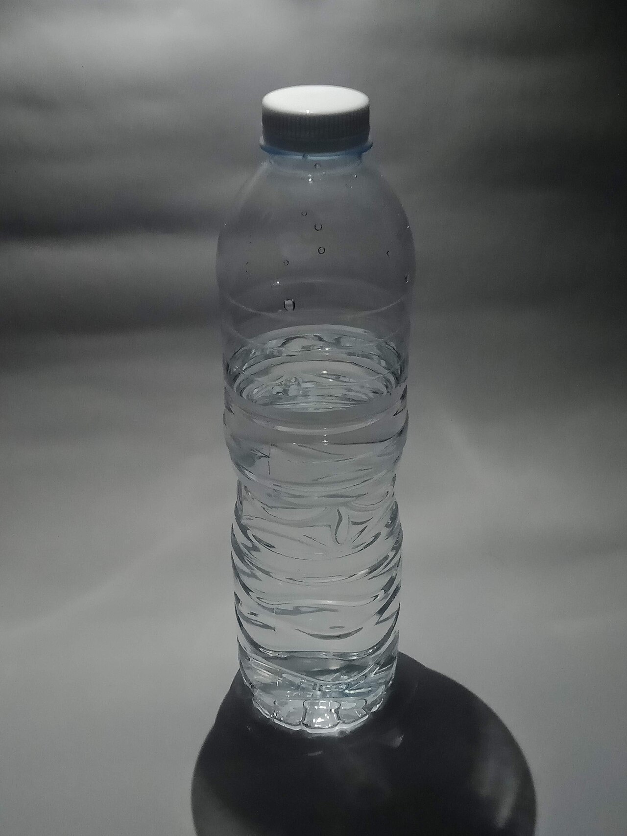 Replacing sweetened beverages with a plain drinking water bottle Clear bottle of plain drinking water carried for daily hydration
